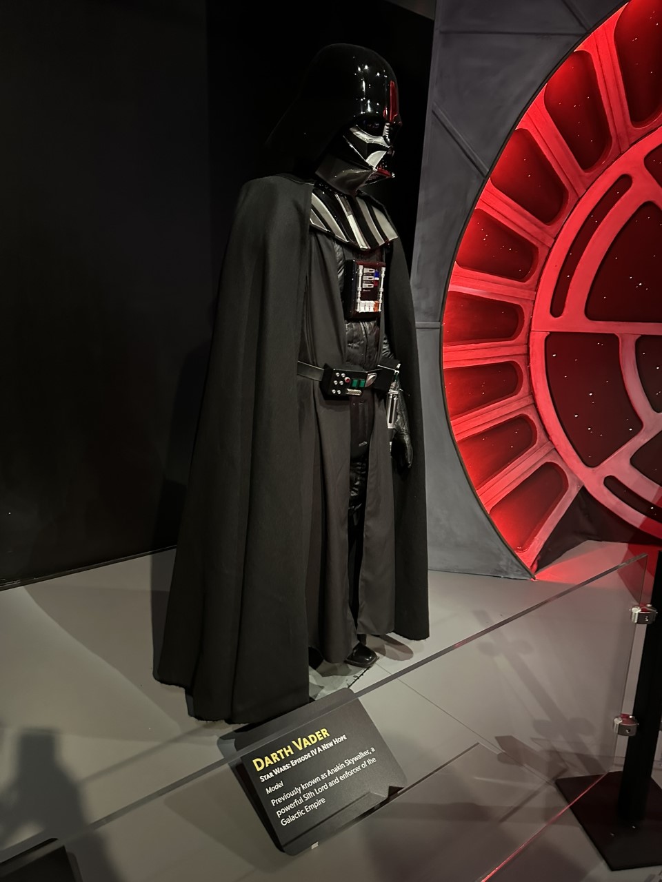 Darth Vader's iconic black armor and cape displayed with Imperial backdrop