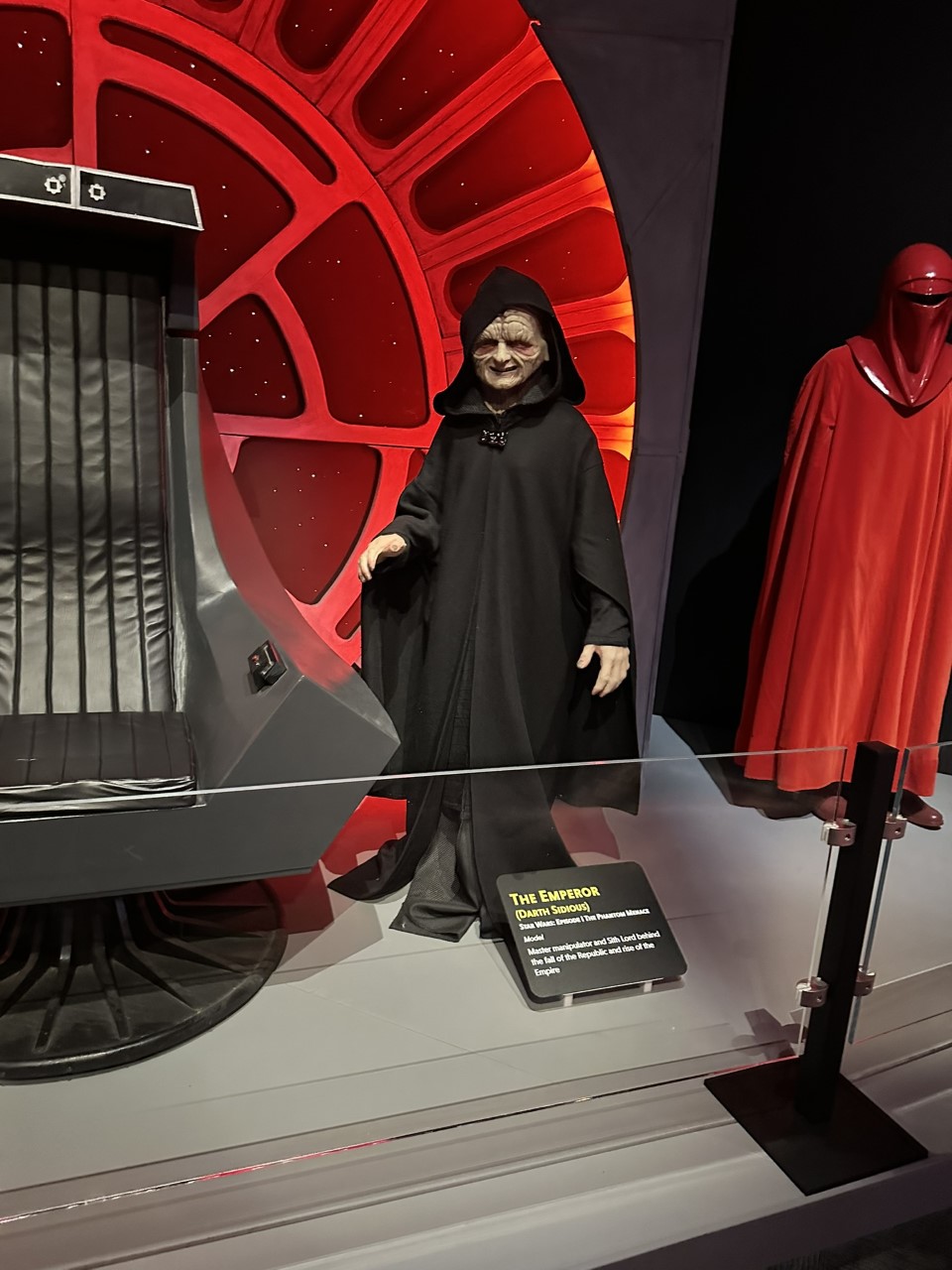 Emperor Palpatine in black hooded robes displayed in Imperial throne room setting